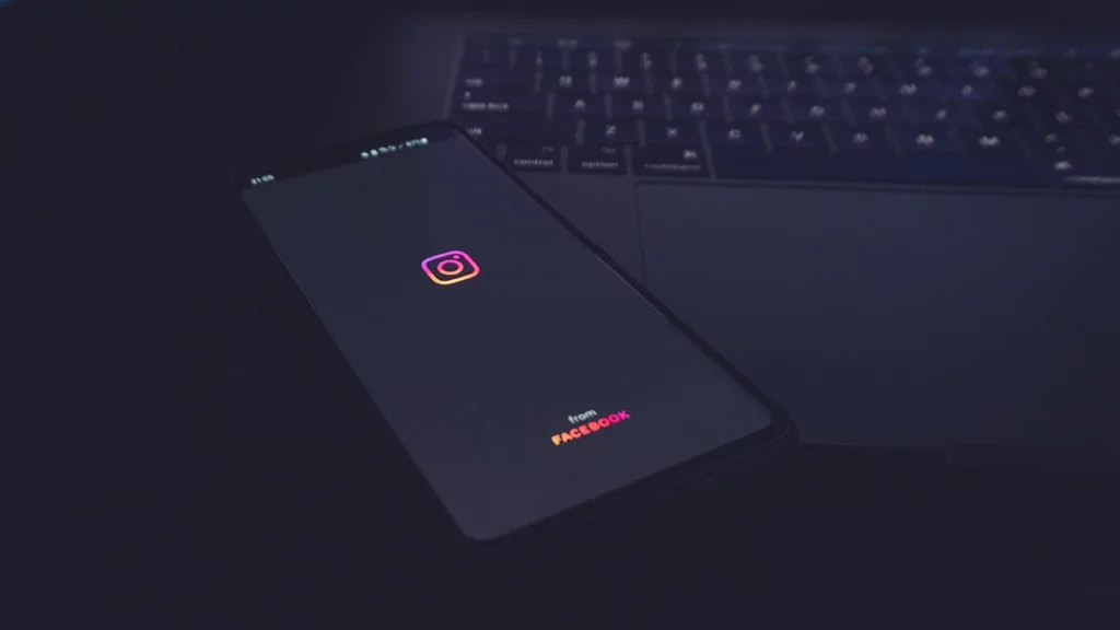 phone with Instagram logo sitting on top of a laptop