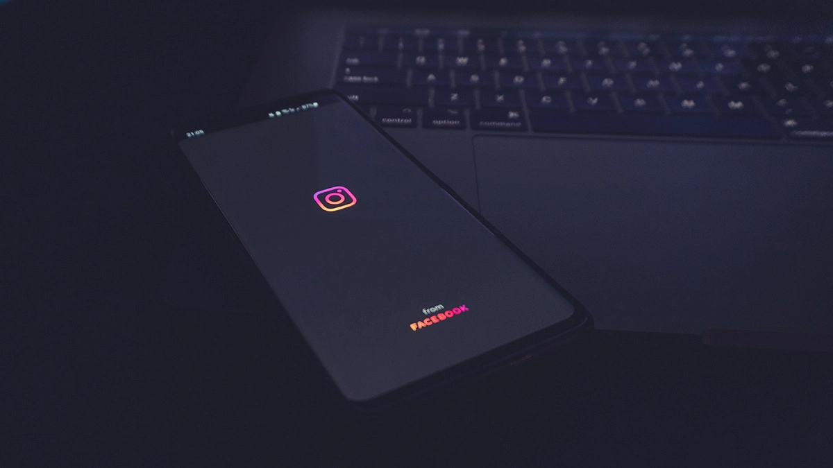 phone with Instagram logo sitting on top of a laptop