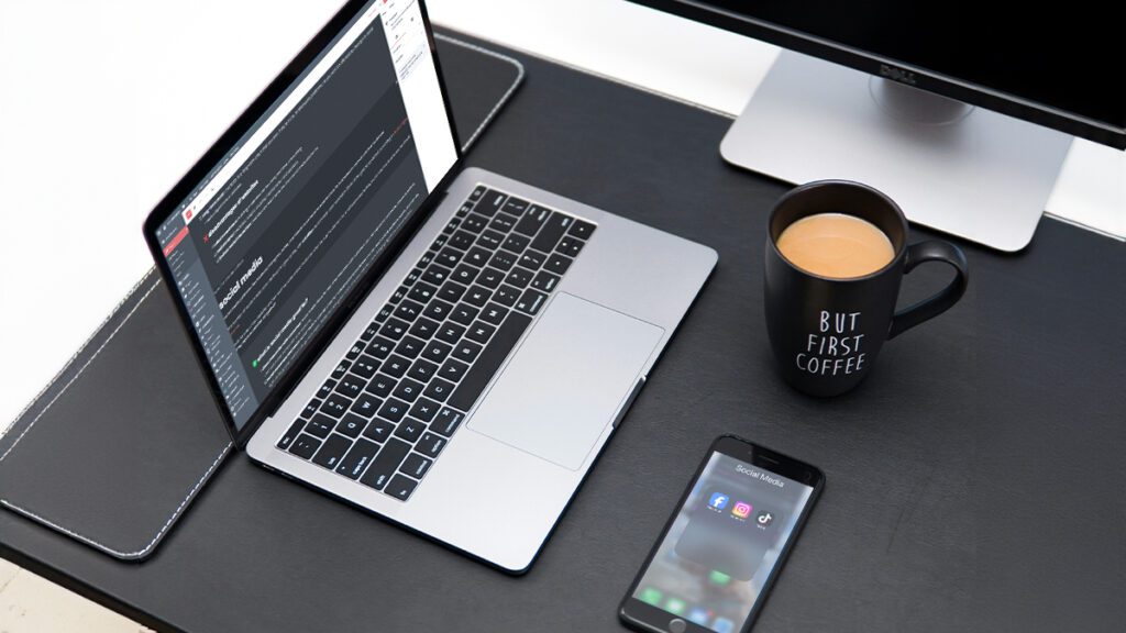 Desktop with laptop, phone and mug of coffee