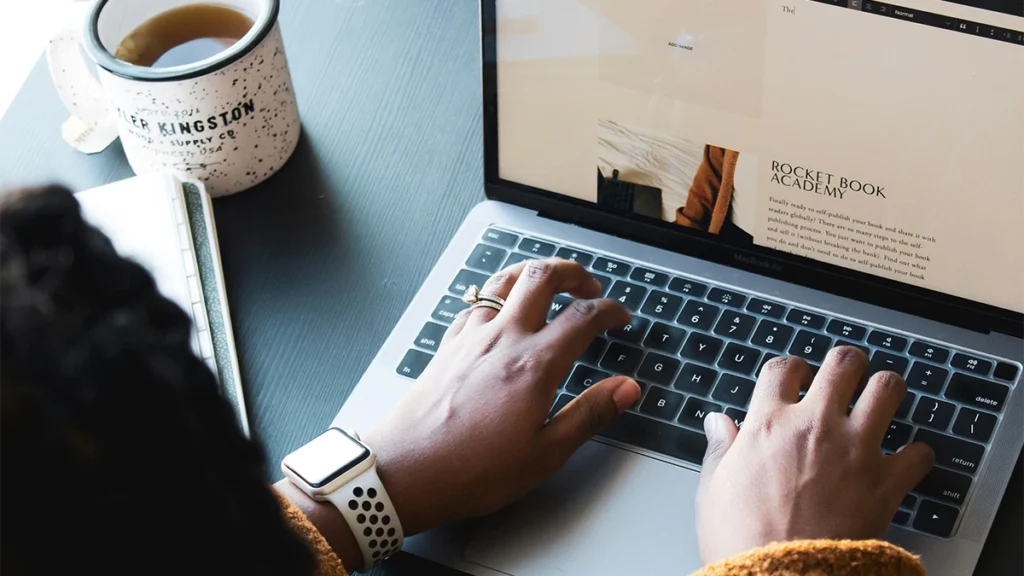 Woman writing a blog post on a laptop
