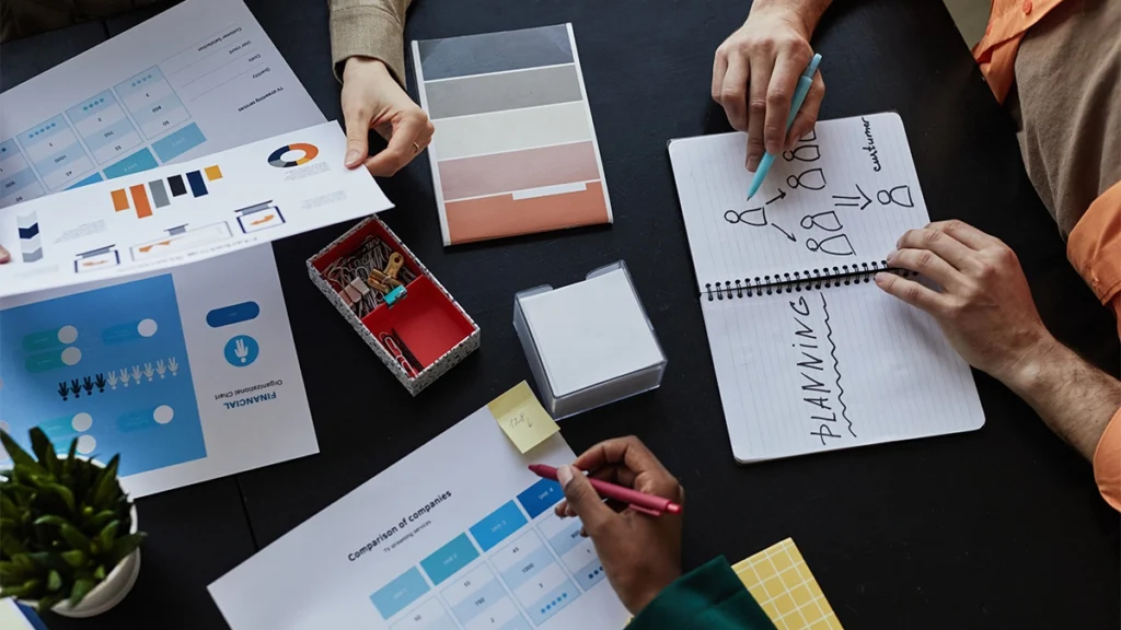 Top down view at table with documents and diverse team planning design project