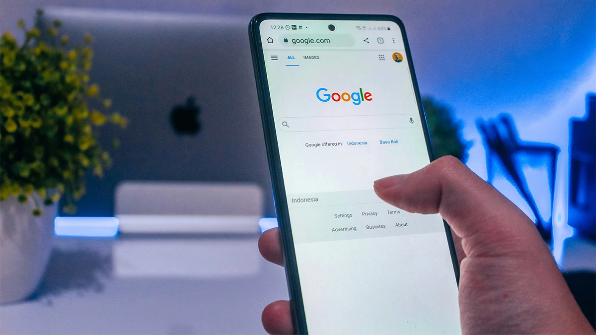 Hand holding phone opening google search looking for something