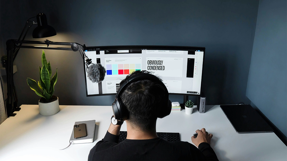 man in black shirt sitting in front of computer working on a rebrand