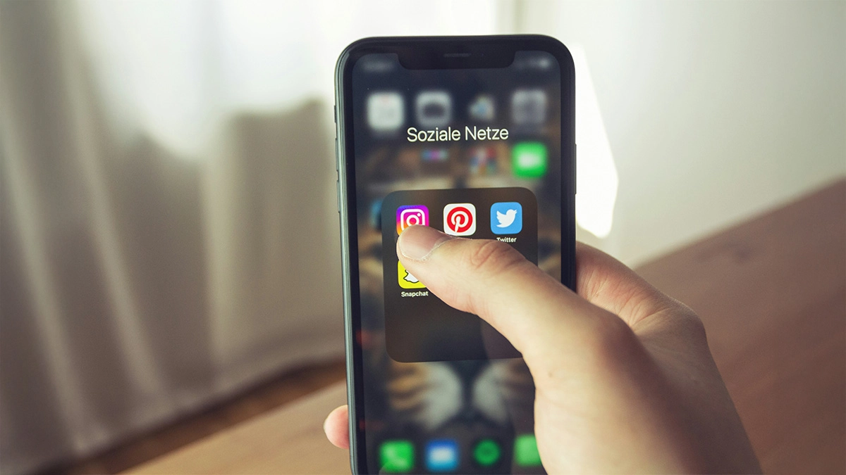 Lady holding a phone with social media apps