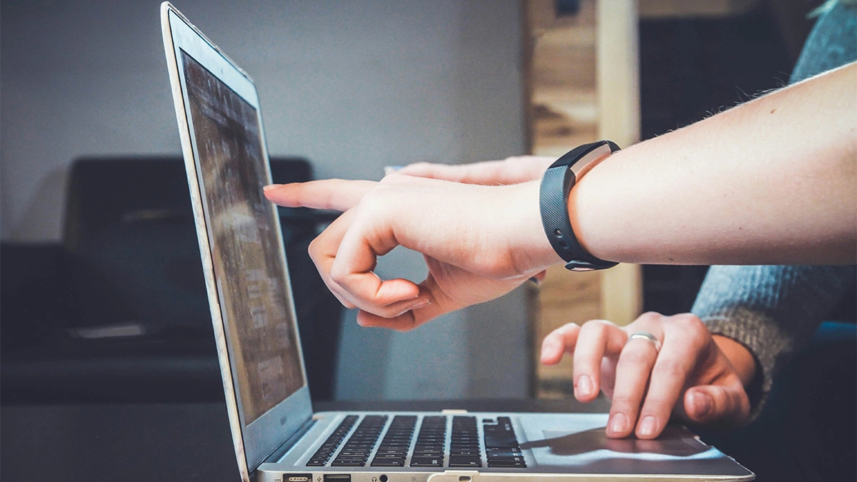 Hands pointing at a laptop