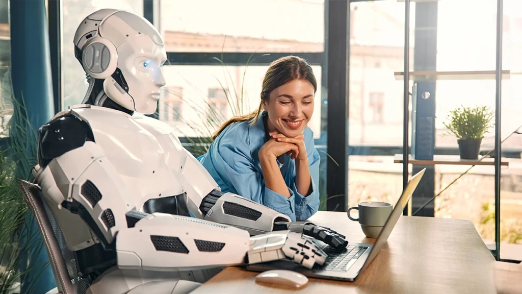 Robot and woman working on laptop