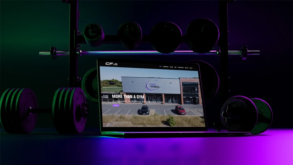 Gym website redesign for Code Fitness Newark displayed on a laptop inside the gym