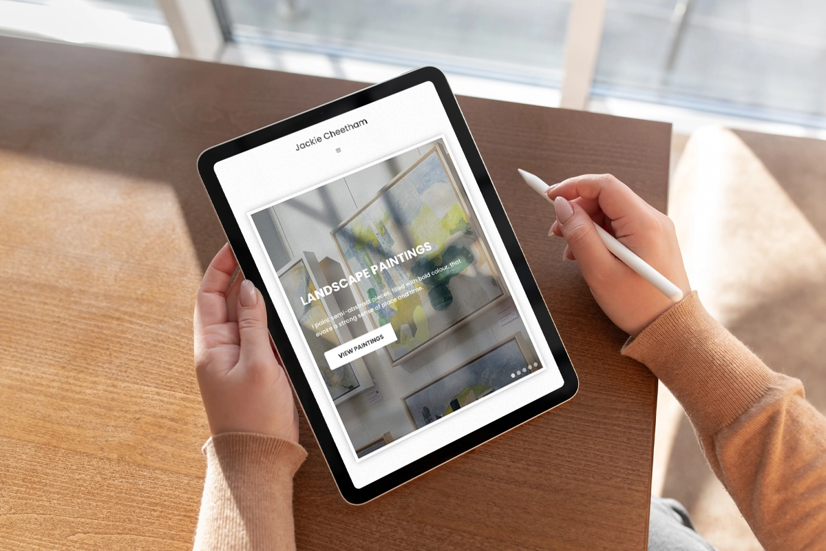 Lady holding a tablet looking at the Jackie Cheetham website
