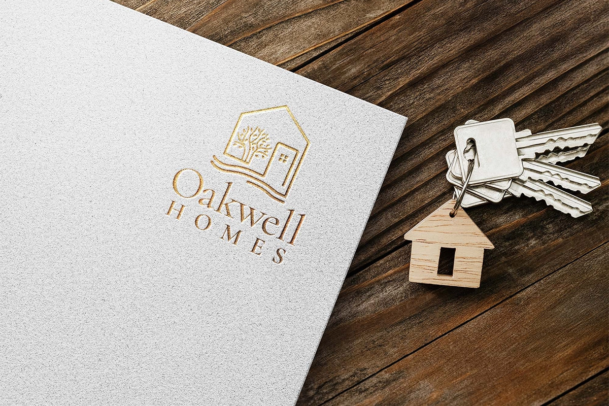 Oakwell Homes logo on a peace of paper, and set of keys, sitting on a wooden desk