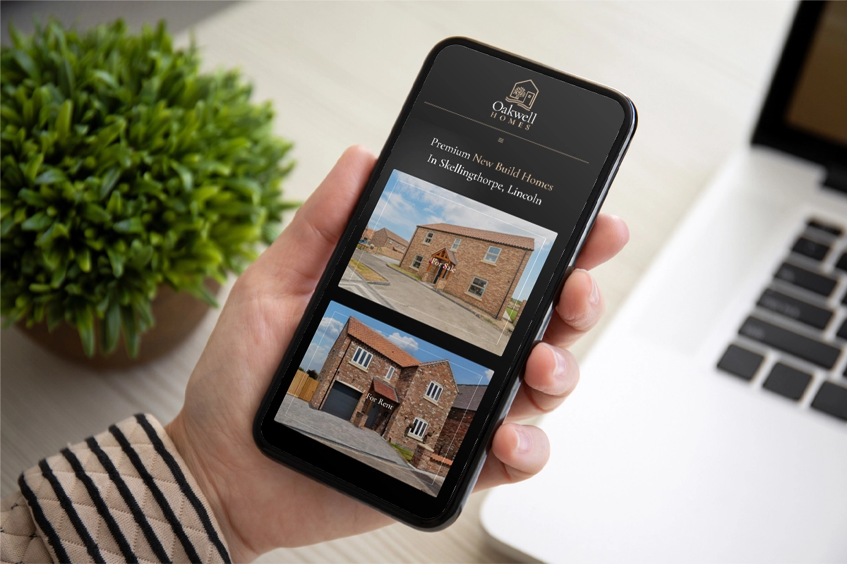 Lady holding a phone looking at the Oakwell Homes website