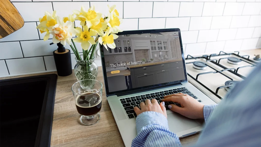Woman looking at the Estu Ltd website on a laptop on the kitchen counter