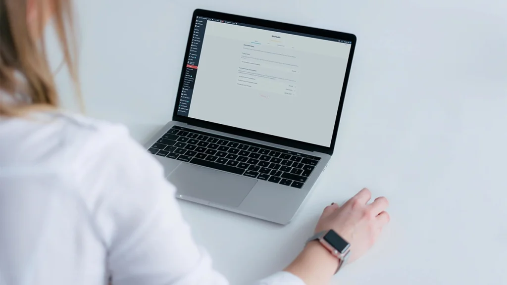 Woman looking at the WordPress Site Health Screen on a laptop