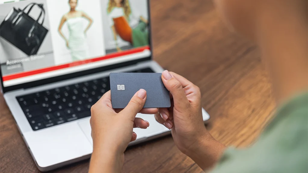 Female holding credit card whilst shopping online