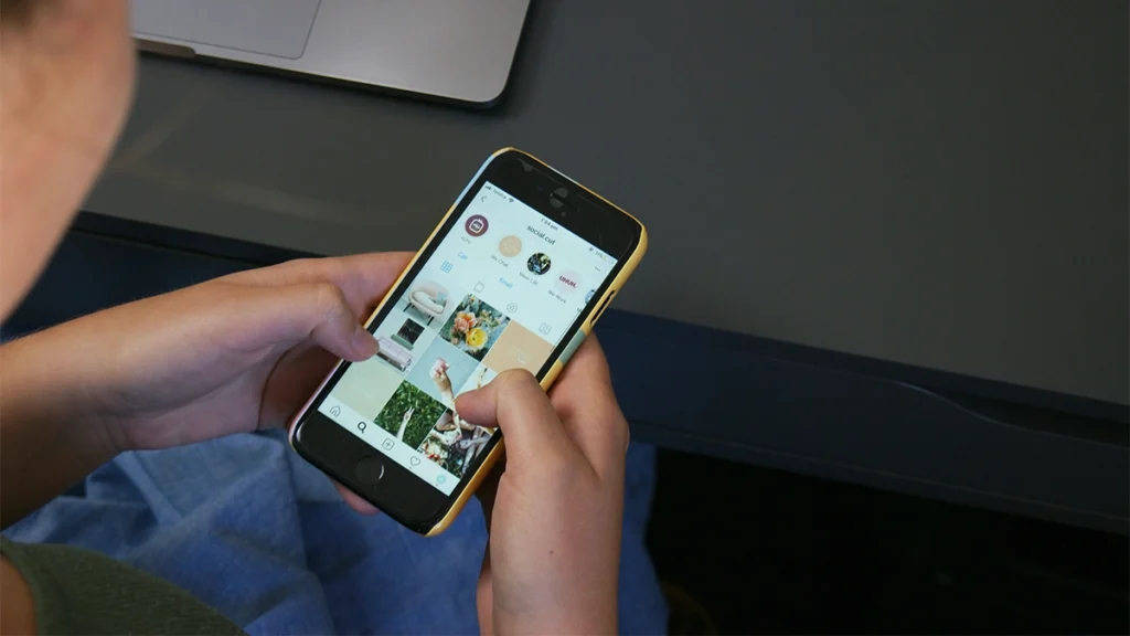 Woman holding a phone with social media feed