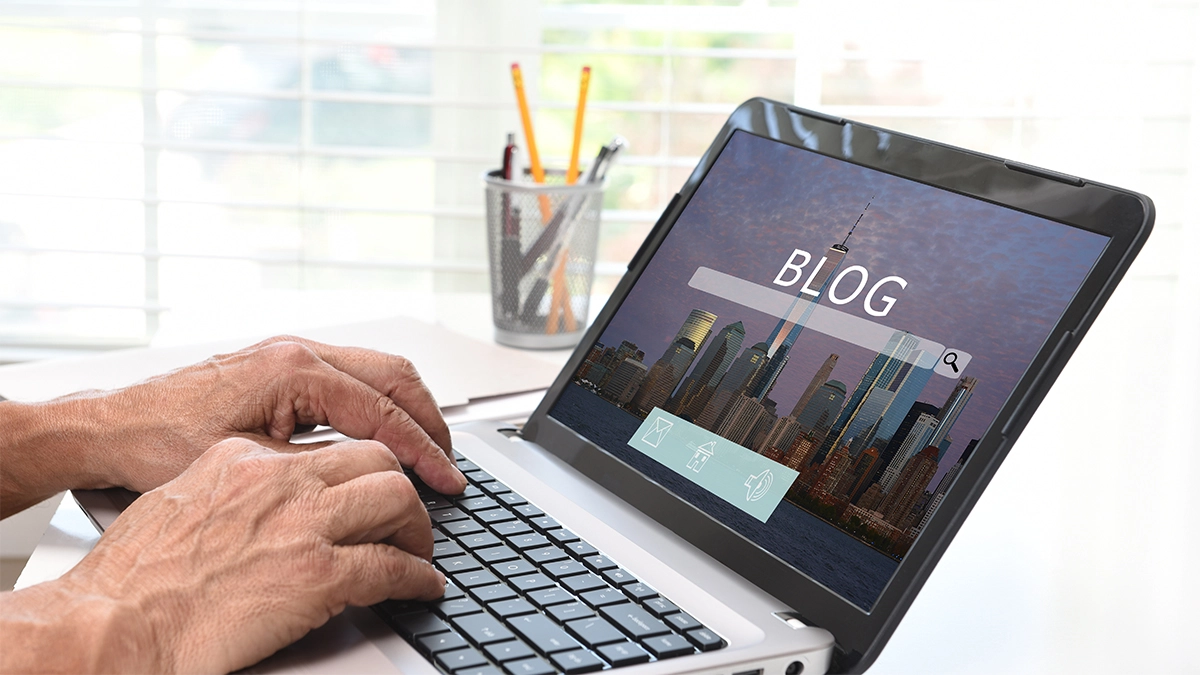 Hands typing on laptop with blog homepage displayed
