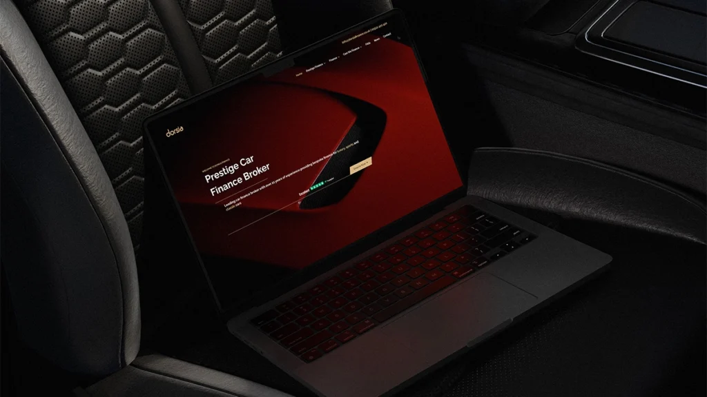 Dorsia Finance website displayed on a laptop which is sitting on the front seat of a car