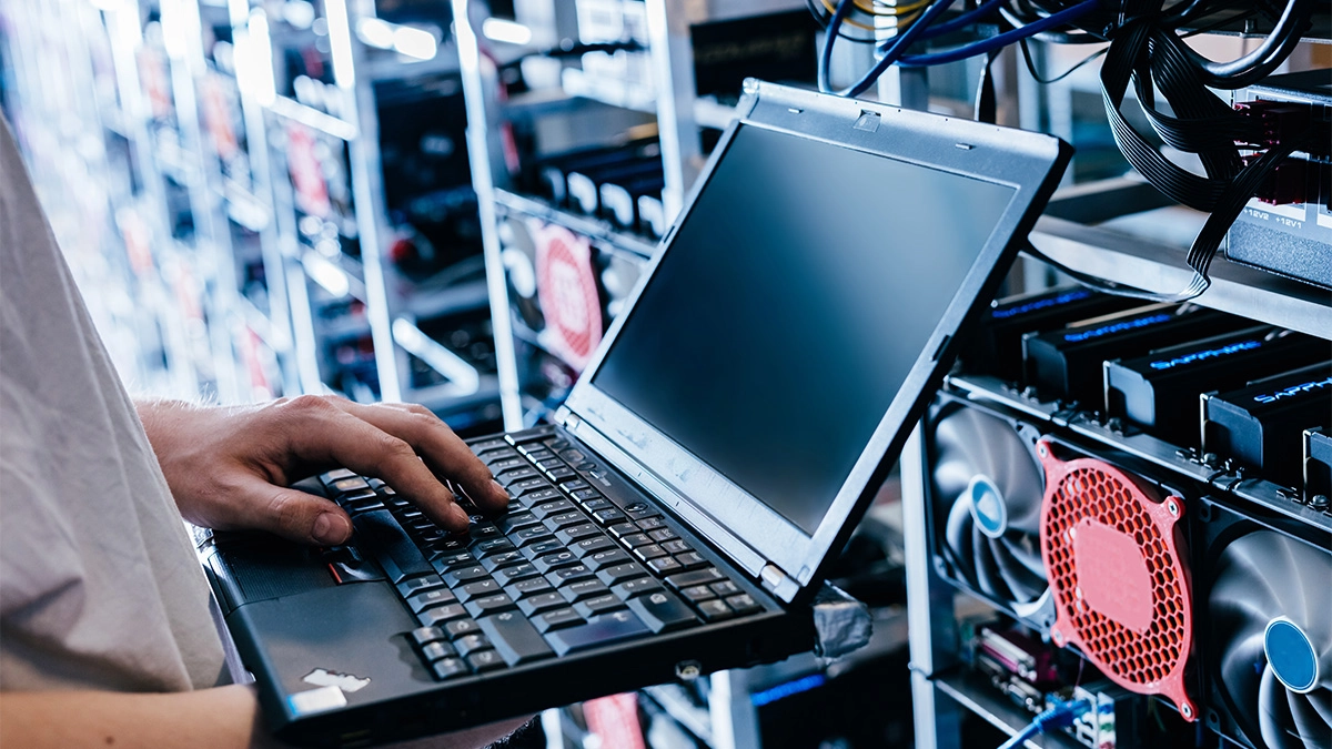 IT specialist working on computer in front of website server