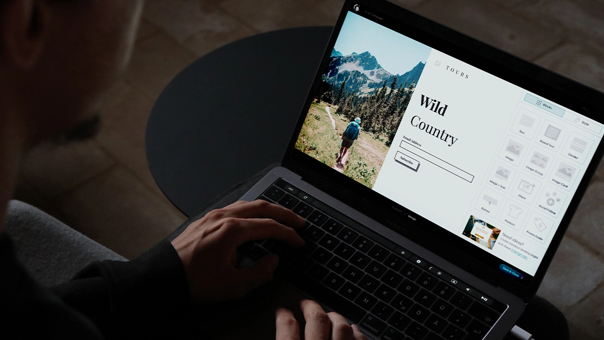 Man creating email campaign landing page on laptop