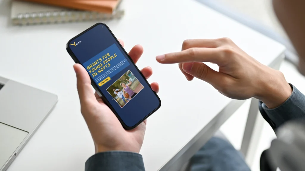 Person holding a phone with Y-Notts website