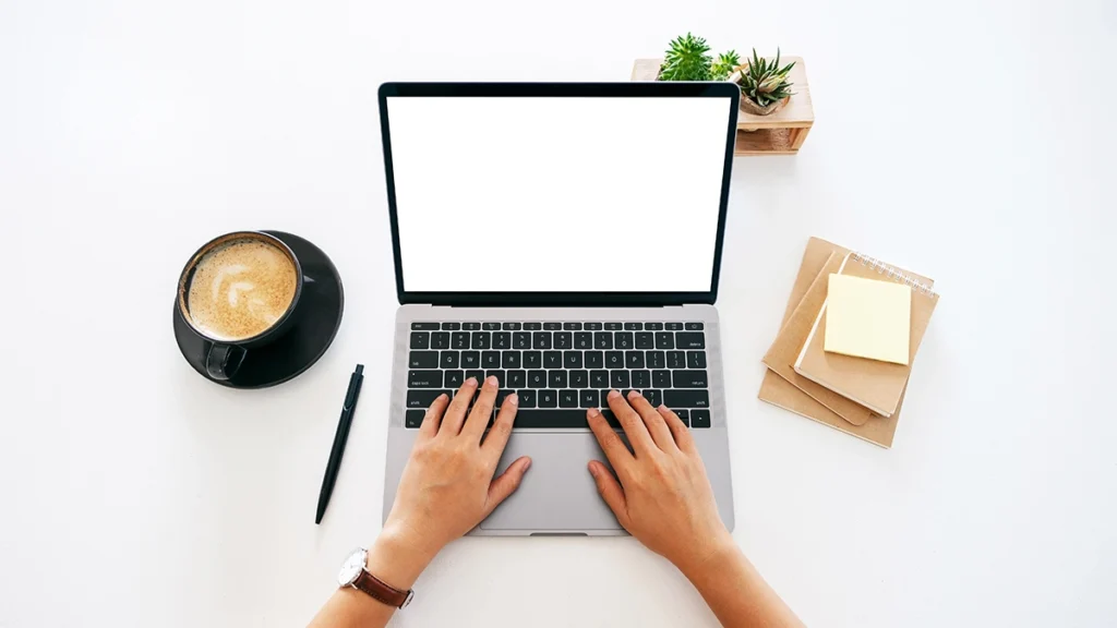 Working at a desk with laptop, coffee and plants